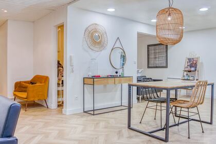 Espace de coiffage du salon, parquet à chevrons et miroirs en rotin